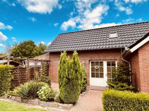 una casa in mattoni con una porta bianca di NEU! Ferienwohnung Tant Anni mit Saunaoption a Ihlow
