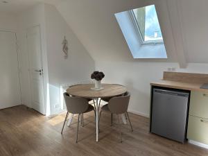 a table and chairs in a kitchen with a window at Le Valory in Granville