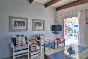 a living room with a desk and chairs and a tv at Dis Beau-tie-ful in Paternoster