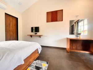 a bedroom with a bed and a dresser and a mirror at Unwind Karjat in Palasdhari