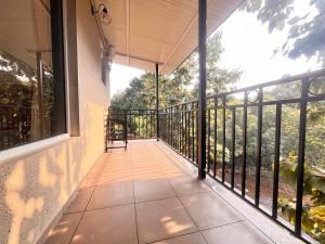 a balcony with a view of the trees at Unwind Karjat in Palasdhari