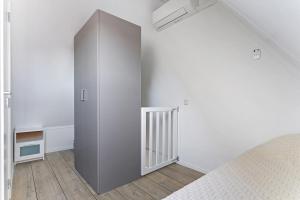 a bedroom with a large gray cabinet next to a bed at Weststraat 22 - Ouddorp - Appartement Oost 3P in Ouddorp