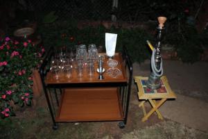 a table with wine glasses on it with a lamp at MAHABALESHWAR HERITAGE villa in Kelghar