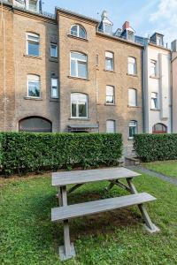 a wooden bench sitting in front of a building at Business Apartment in Wiesbaden