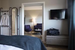 a bedroom with a bed and a television and a chair at Scandic Aalborg Øst in Aalborg