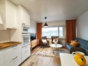 a kitchen and living room with a couch and a table at Keskustan kolmio in Oulu
