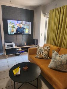 a living room with a couch and a flat screen tv at Ryder Masai Lofts in Farmall