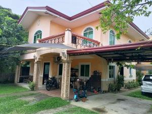 a house with a motorcycle parked in front of it at Joel's House in Iloilo City