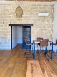 una sala da pranzo con tavolo e sedie e un muro di mattoni di Le petit Corum - HH a Montpellier Altre 2 foto