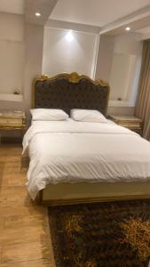 a bedroom with a large bed with white sheets and pillows at H&d abrrtment hotel 5 in Cairo +68 photos