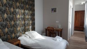 a bedroom with two beds and a wall with a wallpaper at Hostelleire du couvent in Vaylats