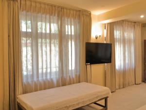 a bedroom with a large window with a flat screen tv at Mundoota House in Jaipur