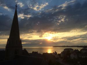 a sunset over a city with a church steeple at Villa Bel-Amy in Saint-Pair-sur-Mer