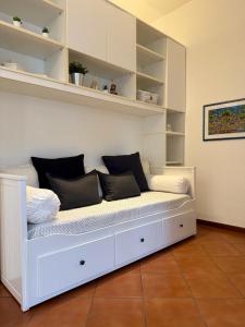 Un banco blanco con almohadas en una habitación. en Vicenza Charm Apartment, en Vicenza