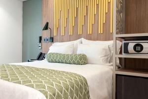 a bedroom with a bed with a tv on it at Sloh Hotel & Bar Manila Medellin in Medellín