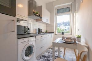 a kitchen with a washing machine and a table at business or holiday in Wiesbaden