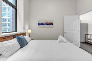 Un dormitorio con una gran cama blanca con ventana. en CozySuites Modern 1BR in Downtown Pitts #20, en Pittsburgh