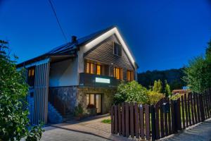 a house with a wooden fence in front of it at MátraForRest in Mátraszentistván