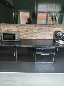 a counter with a microwave on top of it at One bedroom self-catering flat centrally located in Boston