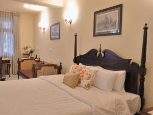 a bedroom with a bed with white sheets and pillows at Mundoota House in Jaipur