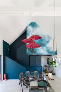 a dining room with red umbrellas on the wall at Villa 4 étoiles en bord de mer - Insolite et Dépaysante in Saint-Jacut-de-la-Mer