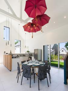 a kitchen with a table with chairs and red umbrellas at Villa 4 étoiles en bord de mer - Insolite et Dépaysante in Saint-Jacut-de-la-Mer +76 photos
