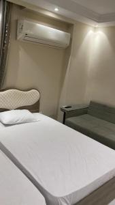 ein Schlafzimmer mit einem weißen Bett und einer Couch in der Unterkunft negm shehab hotel in Kairo