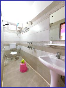 a bathroom with a sink and a toilet and a mirror at Hotel Priyanshi Aradhya Shree Jagannath Temple - Free Wifi and Parking Facilities - Fully-Air-Conditioned Rooms - Best Hotel in Gaya