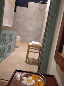 a glass bowl of flowers on a table in a bathroom at Inura Villa in Ambalangoda