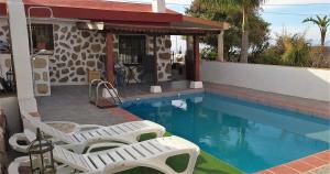 a swimming pool with white chairs and a house at Welcome to your rural retreat, Casita Canaria III in La Sabinita