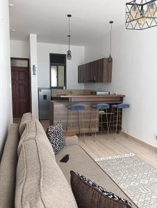 a living room with a couch and a kitchen at Cosy and Elegant apartment in Ntabwe