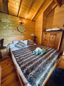 a bedroom with a bed in a wooden cabin at La Cabane à l'Orée des Bornes in Évires