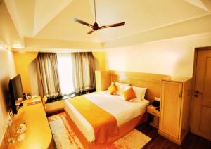 Habitación de hotel con cama y ventilador de techo. en Ira Navi Mumbai, en Kālaj