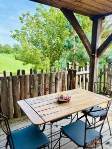 a wooden table and two chairs on a porch at La Cabane à l'Orée des Bornes in Évires