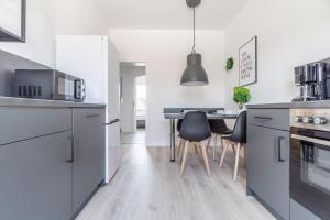 a kitchen with blue cabinets and a table with chairs at Workers Home W136 l 2 Schlafzimmer für 4 Personen in Dinslaken