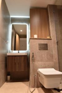une salle de bain avec toilettes, lavabo et miroir dans l'établissement Luxurious Zed park tower pearl, à Sheikh Zayed