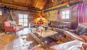 a living room with leather furniture in a log cabin at Chalet spacieux à Saint-Nicolas-la-Chapelle avec cheminée in Saint-Nicolas-la-Chapelle