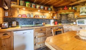 a kitchen with wooden cabinets and a wooden table at Chalet spacieux à Saint-Nicolas-la-Chapelle avec cheminée in Saint-Nicolas-la-Chapelle