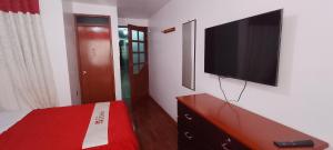 a bedroom with a flat screen tv on a wall at Hotel D'Gloria Churin in Churín