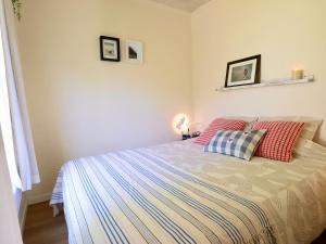 a bedroom with a bed with two pillows on it at La Cabane des artistes 2 - confort, nature et déconnexion in Waulsort