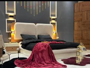 a bedroom with a large bed with a red blanket on it at Alraei 1MH Hotel in Größing