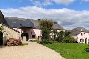 a large pink house with a driveway at Au Petit Bercail - 2 Chambres d'hôtes pour 2 personnes in Chiny