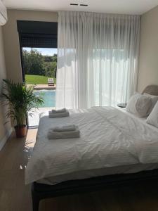 a bedroom with a large bed and a large window at Like a therapy VILLA in Krčedin +52 photos