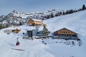 a ski resort in the snow with a ski lift at Berggasthaus Eggberge - Boutique Mountain Hotel - Access via Cablecar in Altdorf