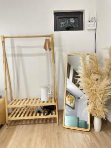 a mirror in a room with a chair and a couch at DK2 Homestay in Hanoi