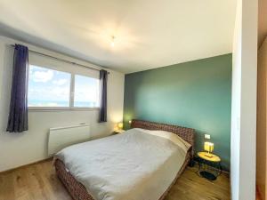 a small bedroom with a bed and a window at Maison Lévi avec vue mer et à 200m du port in Digosville
