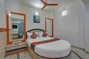 Un dormitorio con una cama grande con espejo. en FabHotel The Black Diamond - Tavarekere, behind Forum Mall, Koramangala, en Bangalore