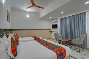 a bedroom with a bed and a table and chairs at FabHotel The Black Diamond in Bengaluru