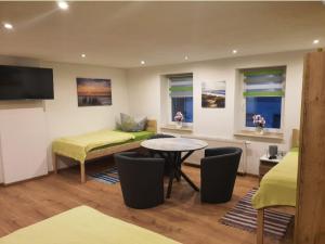 a room with two beds and a table and chairs at Wieprecht`s Vermietung in Deutsches Haus