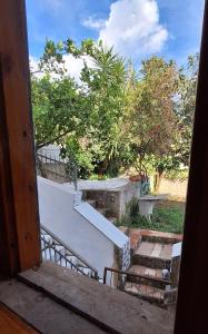 an open door to a balcony with stairs and trees at La Porta Azzurra  +28 photos